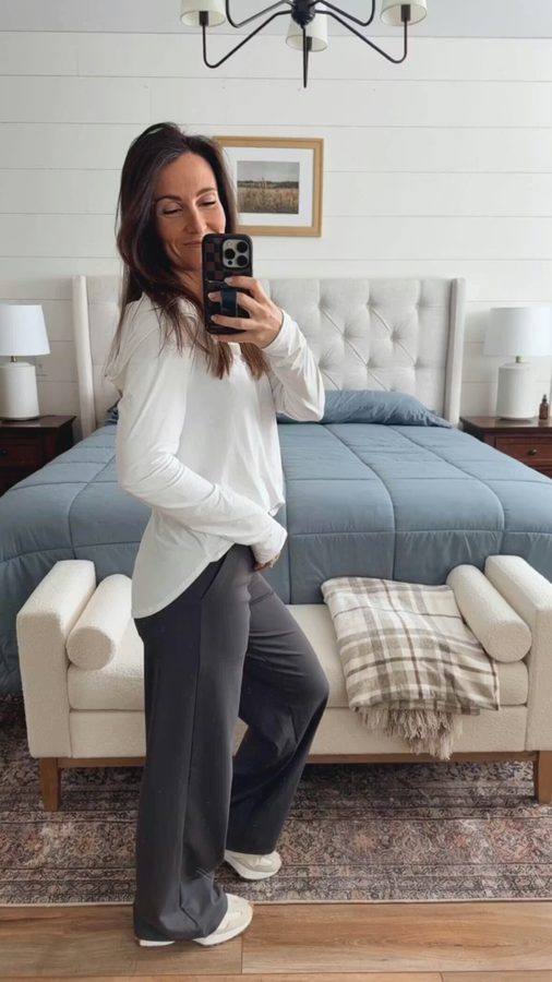 Customer in long-sleeve white tee and gray wide-leg pants