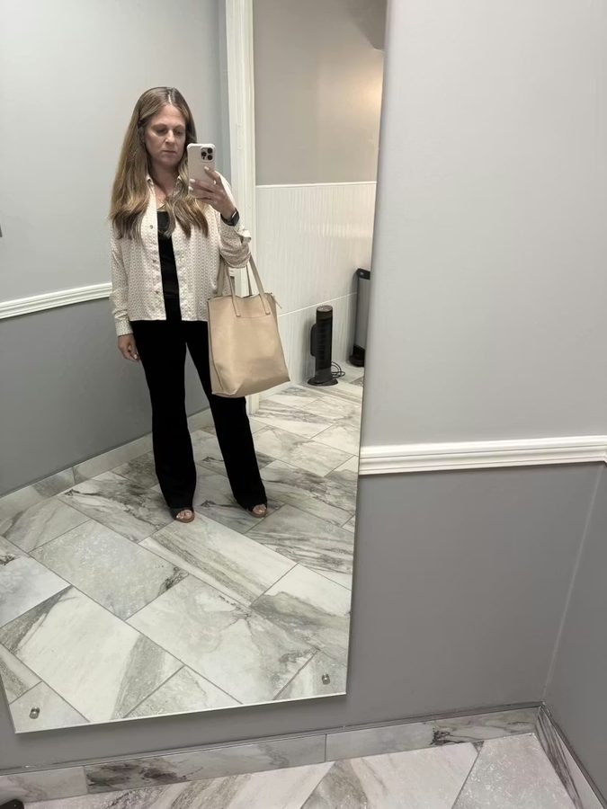 Customer in patterned blouse with tote bag and black pants